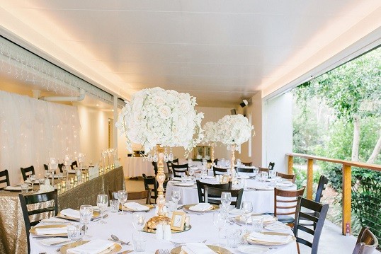 The Garden Terrace set with round tables and tall white florals